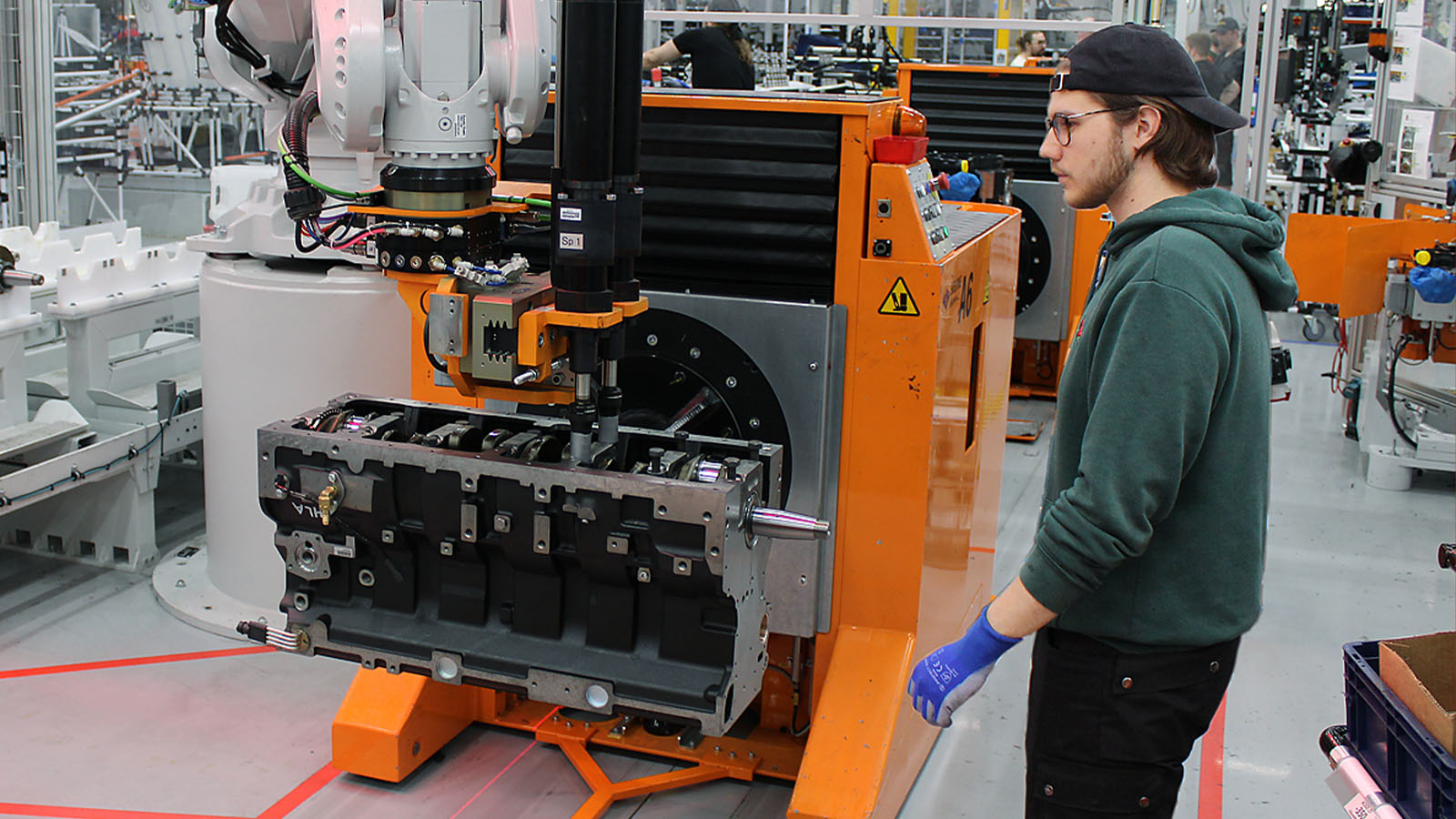 Mechanic Julius Salmela installs a crankshaft with the help of an industrial robot.